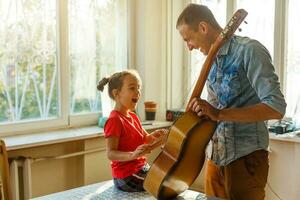 far och dotter nära en bruten gitarr foto