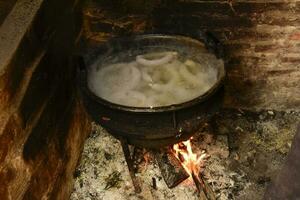 matlagning vit blod korv, i ett järn kastrull, på en spis. foto