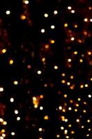 suddigt krans lampor på en mörk bakgrund. festlig jul och ny år bakgrund. mjuk fokus foto