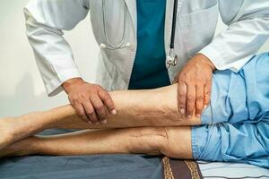 asiatisk äldre kvinna patient visa henne ärr kirurgisk total knä gemensam ersättning sutur sår kirurgi artroplastik på säng i amning sjukhus avdelning, friska stark medicinsk begrepp. foto