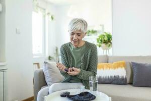 mogna kvinna med glukometer kontroll blod socker nivå på Hem. diabetes, hälsa vård begrepp foto