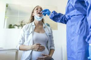 läkare bär personlig skyddande Utrustning utför en coronavirus covid-19 pcr testa, gravid kvinna nasal np och oral op svabb prov prov samling bearbeta, viral rt-pcr dna procedur foto