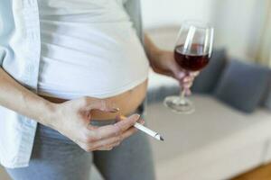 rökning och alkohol graviditet.kvinna på en lång graviditet dricka alkohol och rökning cigaretter.problem av alkoholism och de period av lager en barn.fara av förlorande en bebis, missfall. alkoholhaltig foto