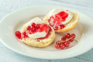 klassisk scones med grädde och bär sylt foto