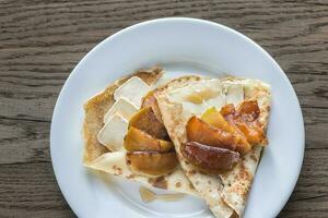 crepes med Brie och caramelized skivor av äpple foto