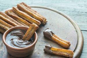 churros - känd spanska efterrätt med choklad sås foto