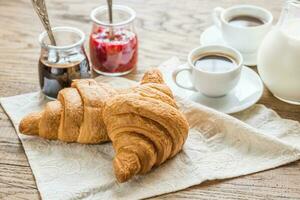 croissanter med koppar av kaffe och mjölk foto