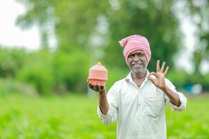 indisk jordbrukare innehav gullak i hand, sparande begrepp, Lycklig fattig jordbrukare foto