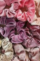 samling av trendig sammet scrunchies på rosa bakgrund foto