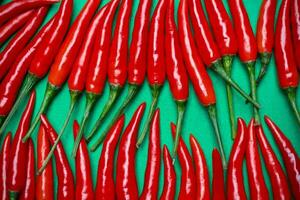 kryddad röd chili på grön bakgrund foto
