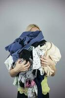 kvinna innehar en massa av skrynkliga kläder i henne händer, kopiera klistra in foto