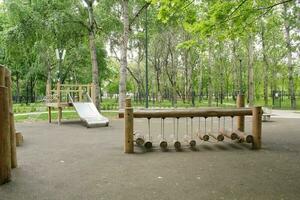 trä- lekplats tillverkad av naturlig miljövänlig material i offentlig stad parkera. modern säkerhet barn utomhus- Utrustning. begrepp av hållbar livsstil och ekologi. barn resten och spel på öppen luft foto