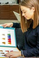 ung caucasian kvinna välja en Färg från de hår Färg Diagram i en skönhet salong. foto