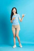 porträtt av leende asiatisk kvinna Framställ på blå bakgrund foto