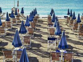 paraplyer på de strand av en ligurian badning etablering. en textur av paraplyer i de sommar av 2023 foto