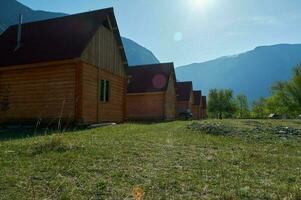 trä- hus mot bergen och klar himmel på gryning. turist bas i altai, sten svamp foto