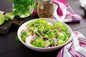 friska vegan mat. vegetarian vegetabiliska sallad av rädisa, gurkor, sallad och röd lök. foto