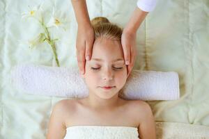 massör håller på med ansikte massage till barn. foto