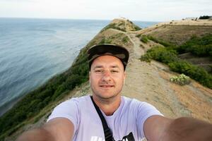selfie av en man på de bakgrund av de hav och berg. cape emine, svart hav kust, bulgarien. foto