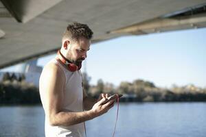 man spelar sporter och lyssnande till musik med hörlurar foto