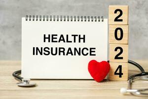 2024 Lycklig ny år för sjukvård, försäkring, wellness och medicinsk begrepp. stetoskop av läkare på tabell foto