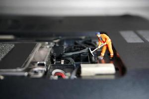 teknikerarbetare figur som står på en gammal USB-flashenhet. det stöder koncept. foto