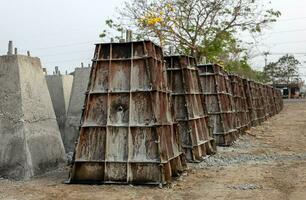 talrik betong pelare baser, som var byggd förbi cement gjutning i en stål låda och fodrad upp i rader. foto