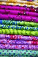 konstnärlig mängd skugga tona textil- tryckt färger tyger staplade på detaljhandeln affär hylla till försäljning foto