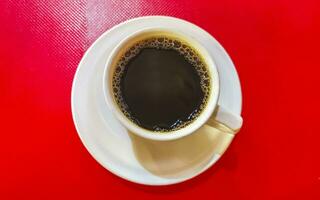 kopp av americano svart kaffe röd bakgrund Mexiko. foto