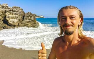 selfie med stenar klippor se vågor strand puerto escondido Mexiko. foto