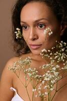 skönhet porträtt av en skön självsäker lugn mörkhårig latinamerikan kvinna med vit Gypsophila kvist. kropp vård, positivitet, sensualitet, förtroende, självacceptans, kvinnlighet, kvinnors dag begrepp foto