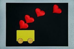 en gul kort med två pengar mynt och röd hjärtan på topp av dem. symbol av kreditera, pengar, bil, kärlek, gåva fot valentines dag. foto