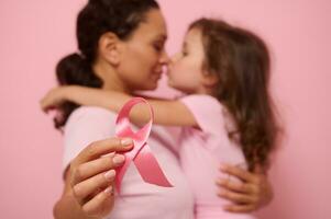 mjuk fokus på rosa satin band, symbol av internationell bröst cancer medvetenhet dag, mot suddig bakgrund av kärleksfull mor och härlig dotter. kvinna sjukvård och medicinsk utbildning begrepp foto