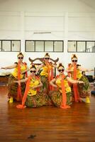 en grupp av traditionell javanese dansare dans mycket vig medan bär solglasögon och gul kostymer på skede foto
