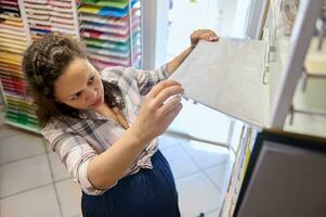 topp se kvinna konsument konstnär målare shopper välja vattenfärg papper i en brevpapper Lagra. hobby. kreativ konst affär foto