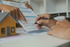 fastighetsmäklare levererar ett prov av ett modellhus till kunden, hypotekslåneavtal gör leasing och köp och sälj hus och kontrakt hemförsäkring hypotekslån koncept foto