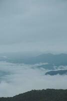 berg räckvidd med synlig silhuetter genom de morgon- blå dimma. foto