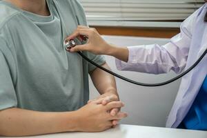 läkare sjukvård. professionell medicinsk läkare i vit enhetlig klänning täcka intervju hört patient betryggande hans manlig patient portion hand foto