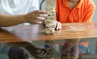 asiatisk far och son spelar trä block spel sorglös unge spelar trä block spel byggnad konstruktör från block med far på Hem foto