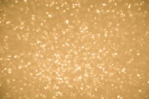 guld glitter bakgrund. skimrande fläck fläck lampor bokeh skinande guld ljus bakgrund. foto