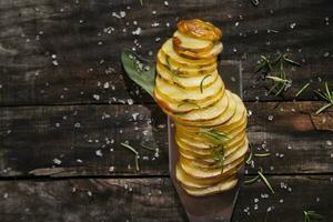 en kniv och en knippa av skivad potatisar på en trä- tabell foto