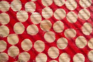 en röd och vit polka punkt mönster på en trä- yta foto