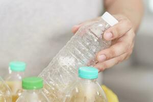 Hem återvinna eco grön noll begrepp man kasta tömma plast flaska i återvinning bin med gul sopor påsar på Hem foto