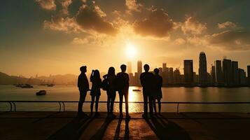 grupp av fyra studenter en pojke och en flicka njut av och fånga stunder på väst kowloon vid vatten promenad hong kong på solnedgång foto