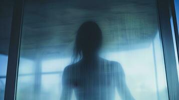 mystisk kvinna Bakom matt glas symboliserar isolering eller sorg foto