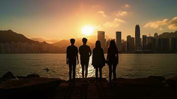 grupp av fyra studenter en pojke och en flicka njut av och fånga stunder på väst kowloon vid vatten promenad hong kong på solnedgång foto