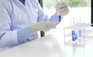 vetenskap innovativ manlig medicinsk eller vetenskaplig laboratorium forskare utför tester med blå flytande i laboratorium. Utrustning vetenskap experiment teknologi coronavirus covid-19 vaccin forskning foto