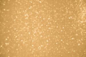 guld glitter bakgrund. skimrande fläck fläck lampor bokeh skinande guld ljus bakgrund. foto