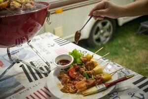 vänner framställning utegrill bbq grillning över en varm brand i de natur.middag fest foto