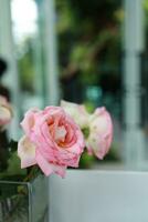 naturlig rosa ro blomma i vas står på tabell i en Kafé för bakgrund foto